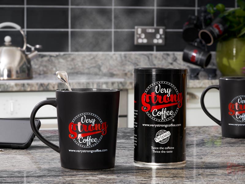 very strong coffee mug and a tin of coffee in the kitchen