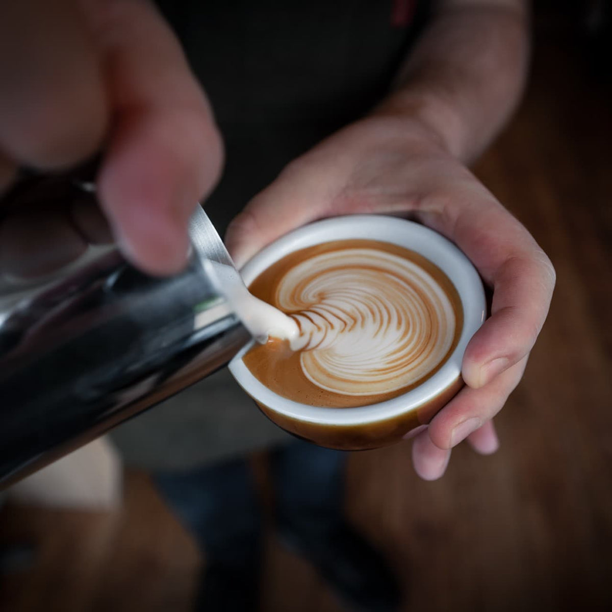 very strong coffee in a cup with milk being poured