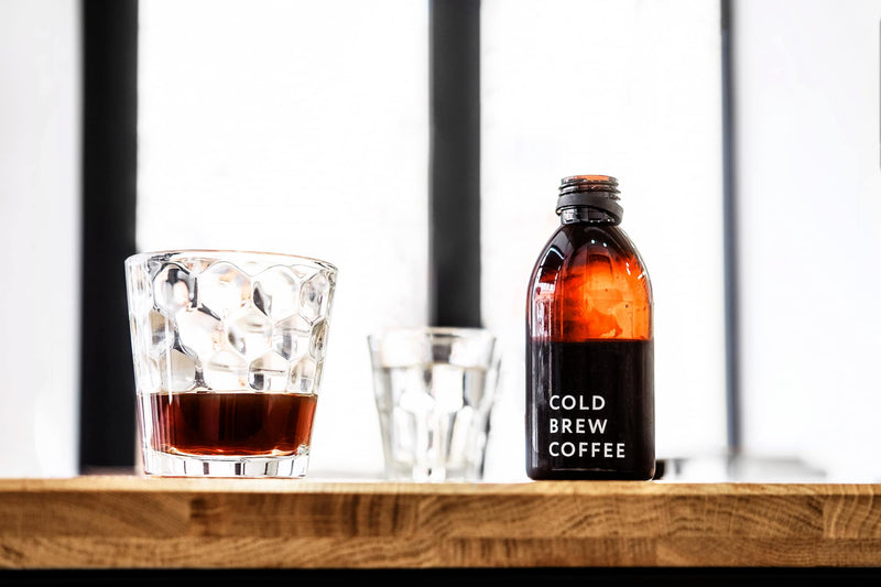 image is on a blog about how to make cold brew coffee - glass with cold coffee in and a bottle with the words cold brew coffee
