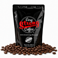 A black stand-up coffee pouch with the brand name 'Very Strong Coffee' printed in red and white, surrounded by scattered roasted coffee beans on a white background.