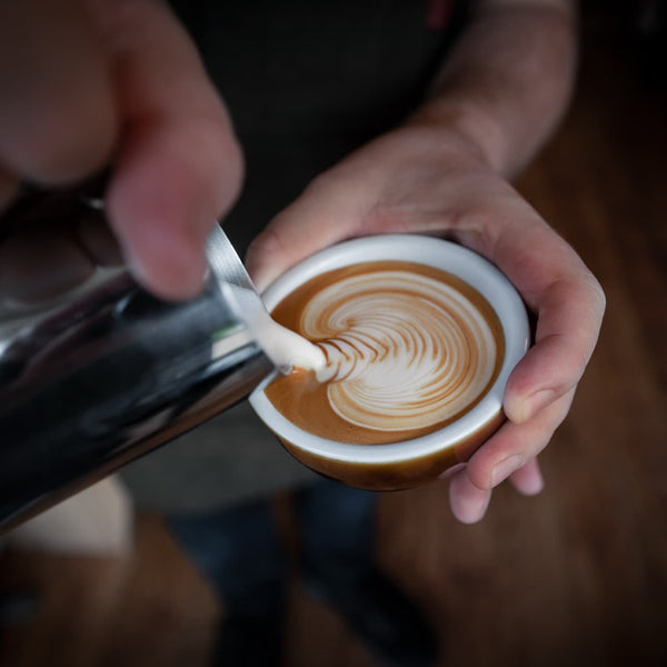 very strong coffee in a cup with milk being poured